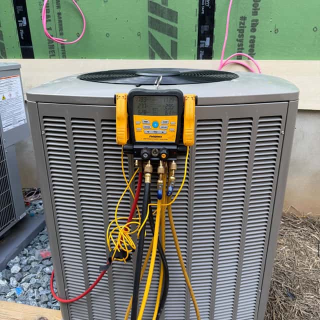 Newly installed condenser with a manifold gauge set connected for commissioning