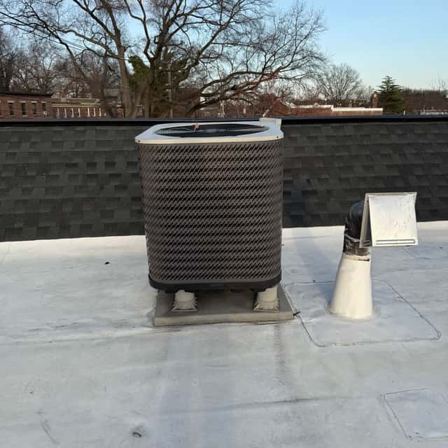 Condenser on a flat roof in a walled rooftop corner