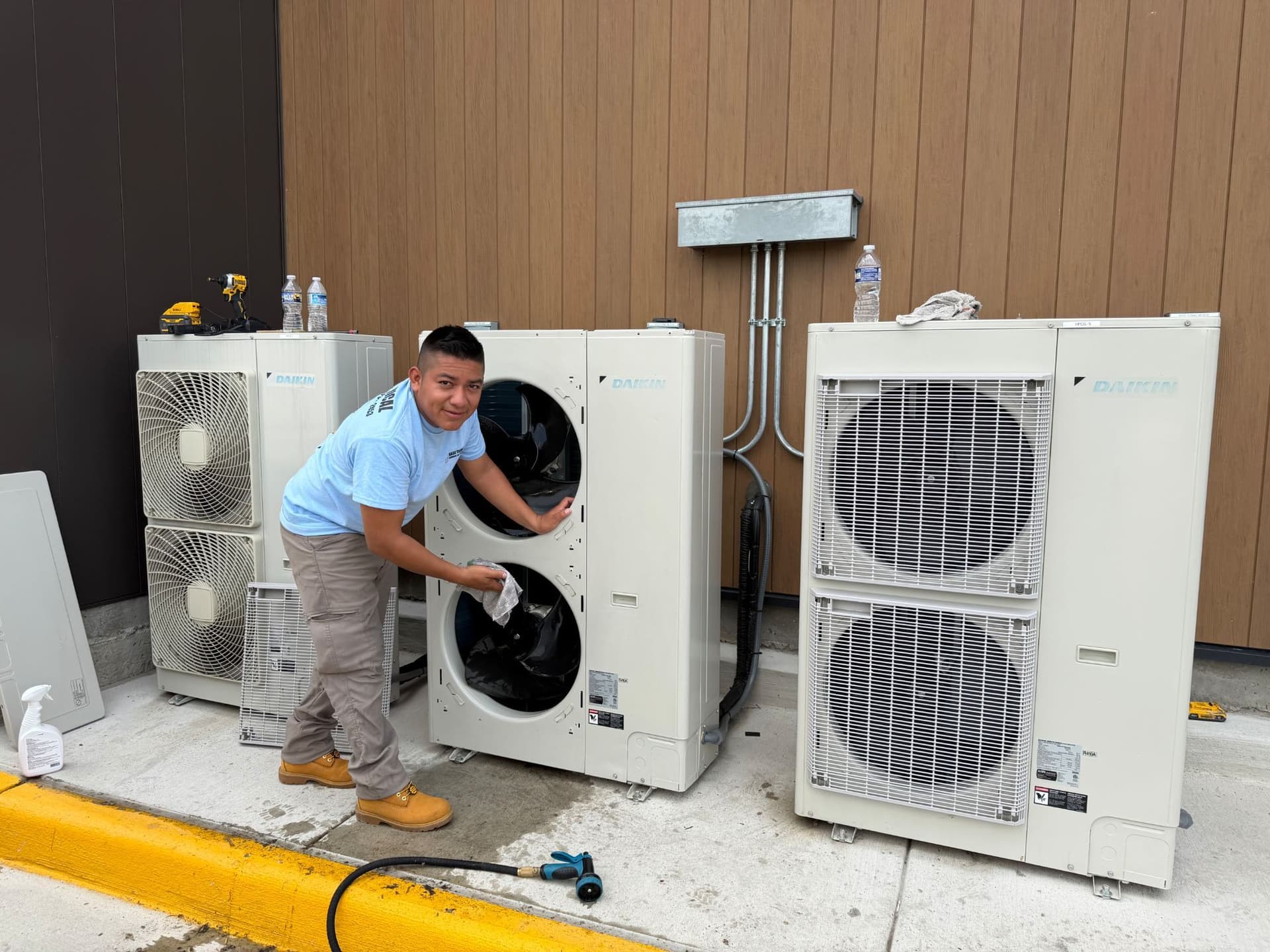 Gask Technical Services technician servicing outdoor HVAC condenser units